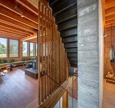 an open living room with wooden walls and stairs