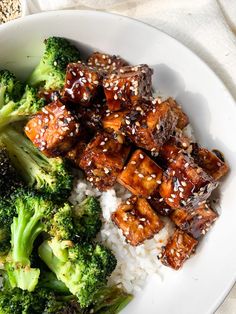 broccoli, rice and tofu with sesame seeds in a white bowl on a table