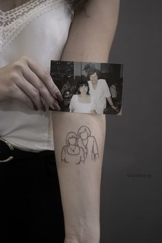 a woman with a small tattoo on her arm holding up a photo and an image of two people