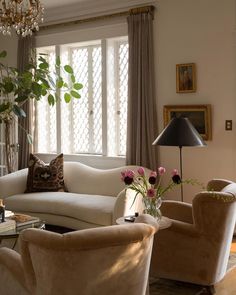 a living room with couches, chairs and a chandelier in the corner