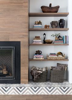 a living room with a fire place and bookshelves on the wall next to it