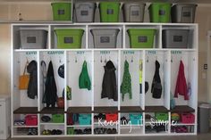 an organized closet with several bins and clothes hanging on the wall next to each other