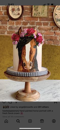 there is a cake decorated with flowers and a horse on the top of it, sitting on a table