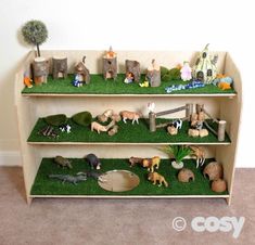 a book shelf filled with lots of toy animals on top of green grass covered ground