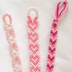 two pink and white bracelets sitting next to each other on top of a table