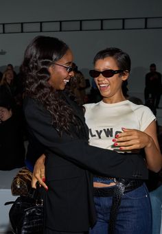 two women standing next to each other smiling