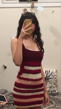 a woman taking a selfie while wearing a dress