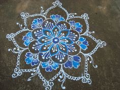 a blue and white flower design painted on the ground with chalk pastel pencils