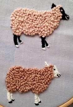 two sheep are shown in the shape of an embroidery pattern on a piece of fabric