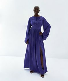 This stunning dress is made of a luxurious semi-satin fabric in a gorgeous deep purple color. It boasts a gathered neckline, wide waistband, and long gathered sleeves. The front-side slit adds a touch of elegance, and the soft rayon lining ensures maximum comfort. The back has a zip to the waist and a top covered button with minimal open slit for a chic look. Meet the Designer: The Baruni collection offers beautiful silhouettes and sophisticated fabrics as unique as you, for every occasion. Fadw Gathered Neckline, Deep Purple Color, Gathered Sleeves, Wide Waistband, Event Dresses, Independent Designers Fashion, Stunning Dresses, Purple Dress, Covered Buttons