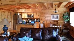 a living room filled with furniture next to a kitchen