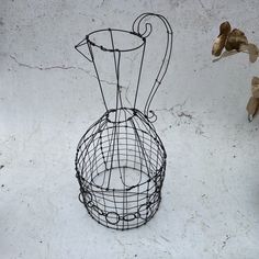 a wire vase sitting on top of a white floor