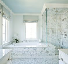 a white bathroom with marble floors and walls