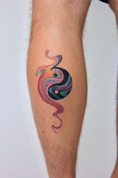 a man's leg with a colorful tattoo on the side of his body, which is shaped like a swirl