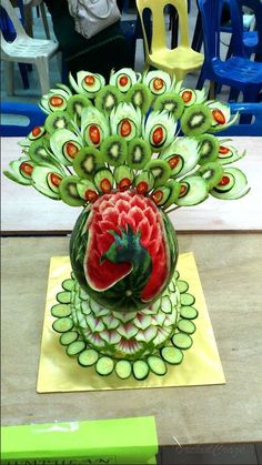 a sculpture made out of fruit and vegetables is displayed on a tabletop with the caption's name below it