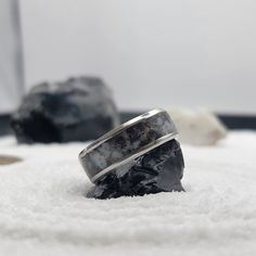 a couple of rings sitting on top of a pile of white towels next to some rocks