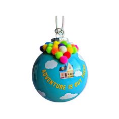 an ornament that says adventure is out there with pom - poms on it