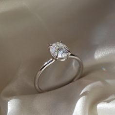 a diamond ring sitting on top of a white cloth