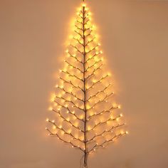 a lighted christmas tree is shown against a white wall with lights on the top and bottom