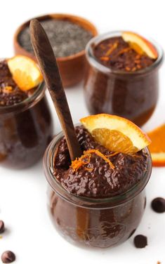 three jars filled with chocolate pudding and orange slices