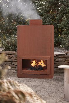 an outdoor fire pit in the middle of a gravel area