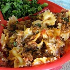 a red bowl filled with pasta and meat