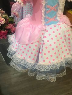 the dress is pink, blue and white with polka dots on it's skirt