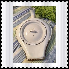 an old porcelain dish with a spoon in it on a striped tablecloth and black border