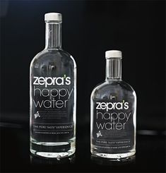 two bottles of zero's happy water sitting on a table next to each other