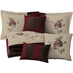 the comforter is made up with red and brown flowers on it, along with matching pillows