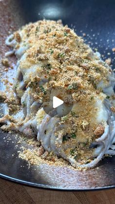 pasta with parmesan cheese and seasoning in a skillet on a wooden table