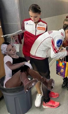 several children are dressed up in costumes as they sit on buckets and hold trays