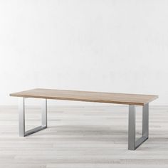 a wooden table sitting on top of a hard wood floor next to a white wall