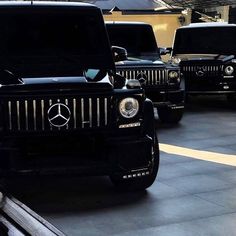 several black jeeps are parked in a parking lot