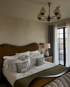 a large bed sitting next to a window in a bedroom