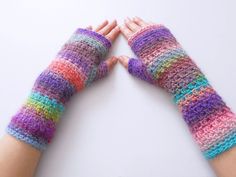 two hands with colorful knitted gloves on them