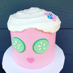 a pink cake with white frosting and green eyes