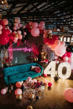 a room filled with balloons and furniture next to a number 40 sign on the wall