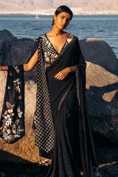 Black saree with embroidered spreads on hem and border work. Comes with floral and geometric embroidered blouse with one shoulder drapes.
Component: 2
Pattern: Embroidered
Type Of Work: Geometric, Floral Patterns
Neckline: Plunged V-Neck
Sleeve Type: Sleeveless
Fabric: Crepe
Color: Black
Other Details: 
Shoulder draped blouse
Note: Dupatta shown in the image is not for sale
Occasion: Destination Wedding - Aza Fashions Sahil Kochhar, Sarees Black, Drape Saree, Draped Blouse, Black Saree, Blouse For Women, Blouse Online, Indian Sarees, Embroidered Blouse