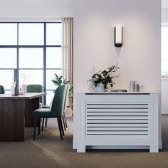 a room with chairs, a table and a plant on the wall in front of it