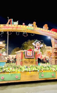 the entrance to mickey mouse's christmas wonderland at night with lights and decorations on display