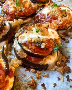 several stuffed eggplant pizzas with cheese and tomato sauce on a baking sheet