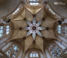 the inside of a cathedral looking up at the ceiling and stained glass windows in it