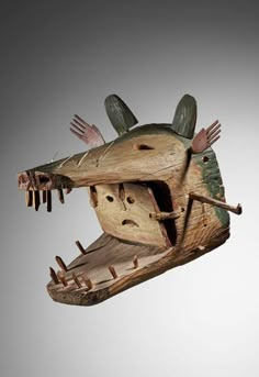 a wooden sculpture of a mouse with its mouth open