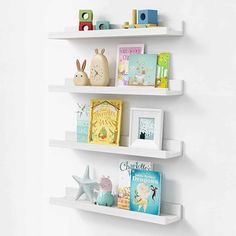 three white shelves with children's books on them