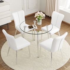 a glass table with white chairs around it