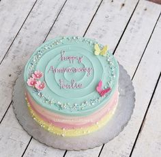 a birthday cake with butterflies on it sitting on a table