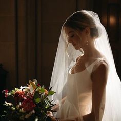 a woman in a wedding dress standing next to a bouquet