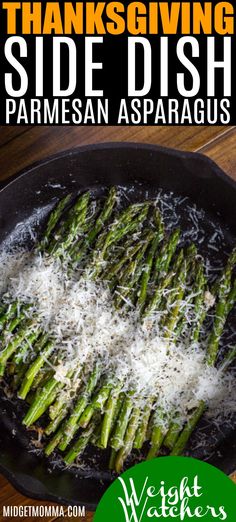 a pan filled with asparagus covered in parmesan cheese on top of a wooden table