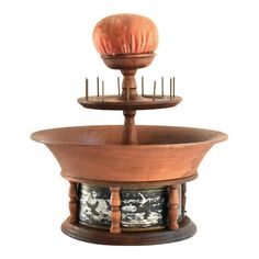 two tiered wooden stand with an orange ball on it's top and pins in the bottom